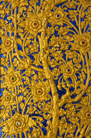 Gold carve flower and animal on blue background  Chiang Mai public temple doorの写真素材