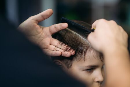 Little Boy Getting Haircut By Barber While Sitting In Chair At Barbershop.の写真素材