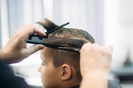 Little Boy Getting Haircut By Barber While Sitting In Chair At Barbershop.の写真素材