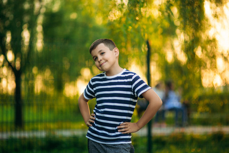 A little boy in a striped T-shirt is smiling and cheering.Spring, sunny weather.の写真素材