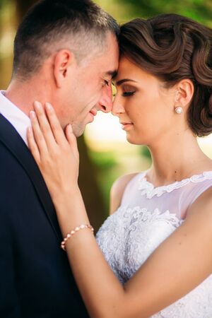 Beautiful couple walking in the park in their wedding day. Sunny weather.の写真素材