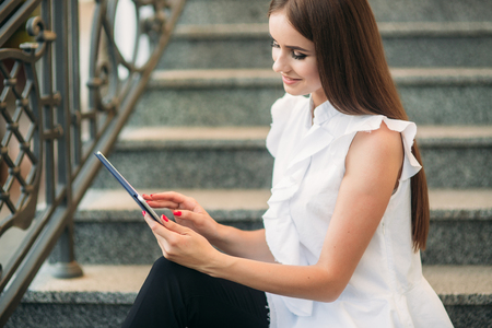 Business lady uses a tablet in the park during a breakの写真素材