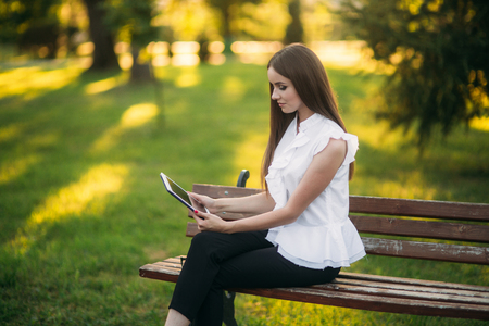 Business lady uses a tablet in the park during a breakの写真素材