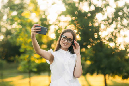 Business lady uses a tablet in the park during a break. Business woman in the park.の写真素材
