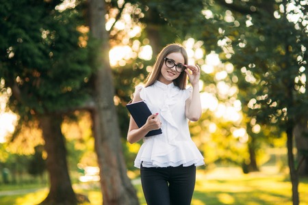 Business lady uses a tablet in the park during a break. Business woman in the park.の写真素材