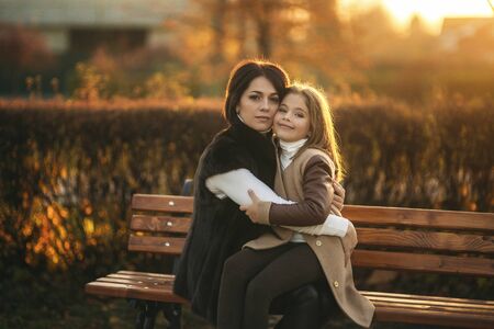 Little girl with mother walking in the park in autumn. Golden autumn.の写真素材
