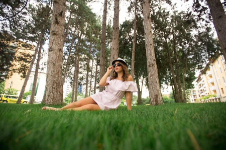 Beautiful girl in the park. Green grass and sunny weatherの写真素材