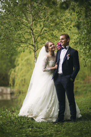 Beautiful couple walking in the park in their wedding dayの写真素材