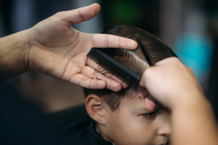 Little boy on a haircut in the barber sits on a chair.の写真素材