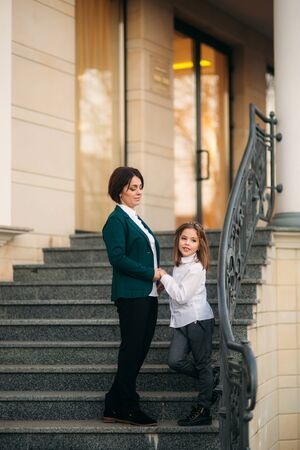 Little girl with mother walking in the park in autumnの写真素材