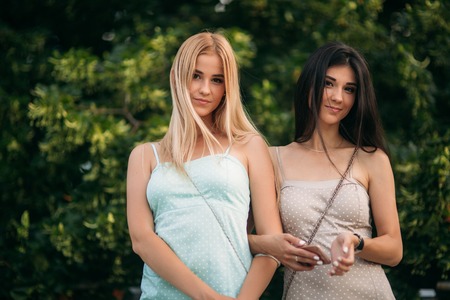 Brunette and blonde are photographed and enjoy life. Sunny day. Summer.の写真素材