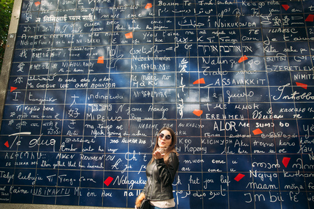 Beautiful girl is walkin in paris near the basilica. tje wall of the loveの写真素材