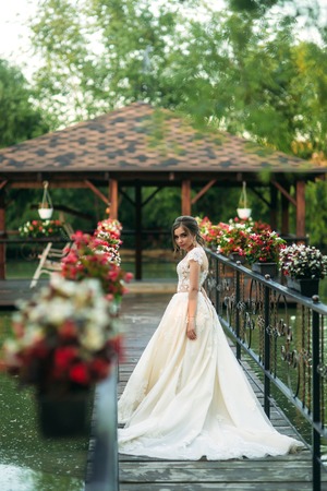 Young girl in wedding dress in park posing for photographer. Sunny weather, summerの写真素材