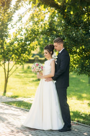 Beautiful newlyweds walking in the park admiring each otherの写真素材