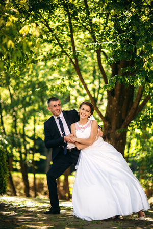 Beautiful couple walking in the park in their wedding day. Sunny weatherの写真素材