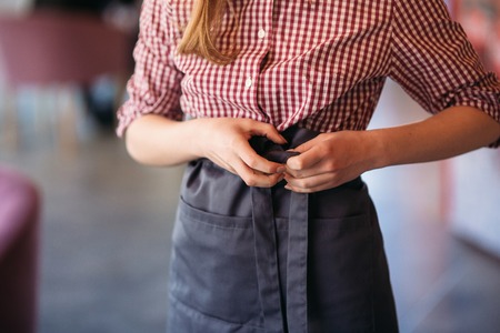 Mid section of waitress wearing apron at cafeの写真素材