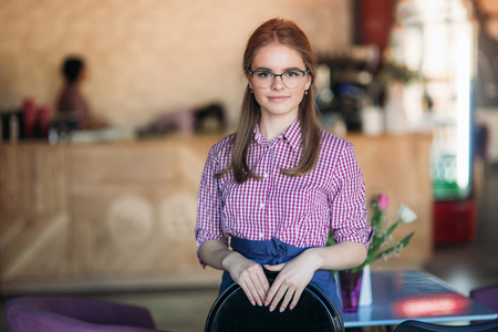 Beautiful waitress standing in cafeの写真素材