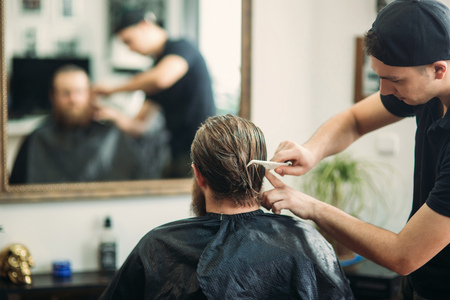 Male client getting haircut by hairdresserの写真素材