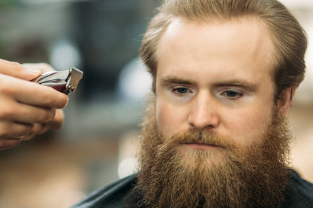 Bearded Man having a haircut with a hair clippers