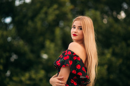 Blonde girl in red dress posing to the photographer