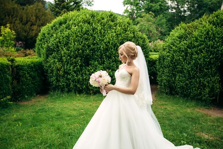 Bride in park with bouquetの写真素材