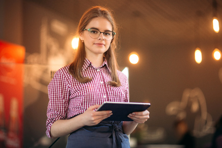 Attractive young waitress using a tablet computerの写真素材