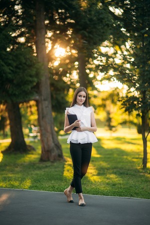 Business lady uses a tablet in the park during a breakの写真素材