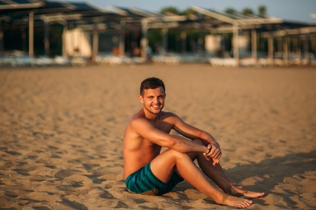 Man sits on sandy beachの写真素材