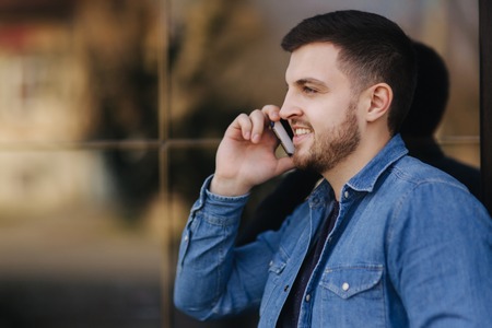 Hamdsome beard man taking a call on his phoneの写真素材