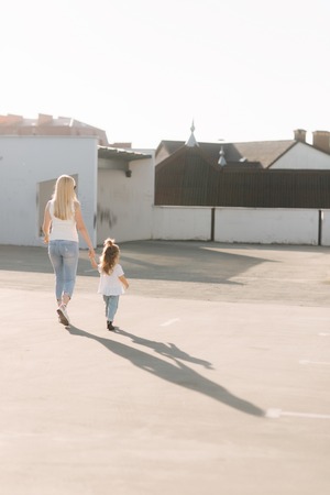 mom and her daughter walking and holding handsの写真素材