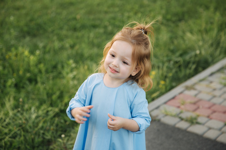 Little girl in blue dress walk in parkの写真素材