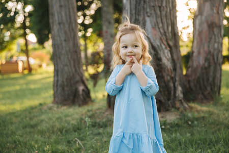 Little girl in blue dress walk in parkの写真素材