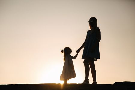 Silhouette of mother and little daughterの写真素材