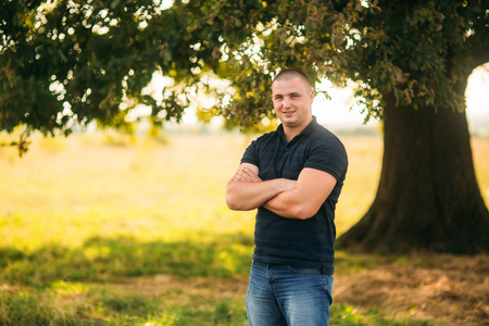 Attractive guy stand near a large green tree. Love storyの写真素材
