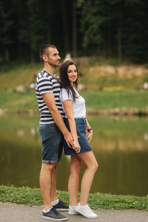 Beautiful couple walking in the park near the lakeの写真素材