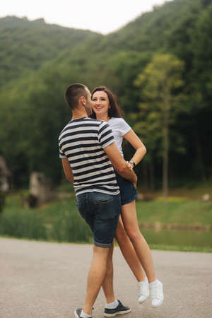 Beautiful couple walking in the park near the lakeの写真素材