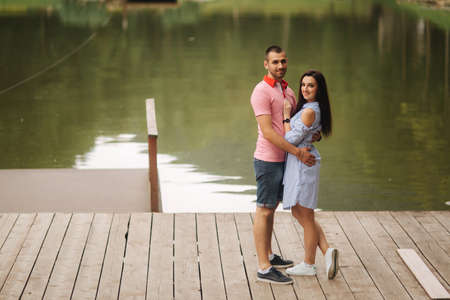 Beautiful couple walking in the park near the lakeの写真素材