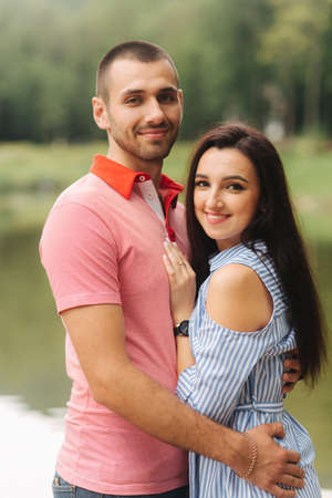 Beautiful couple walking in the park near the lakeの写真素材