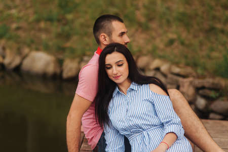 A guy and a girl enjoy each other in a romantic atmosphere, sits on the pierの写真素材