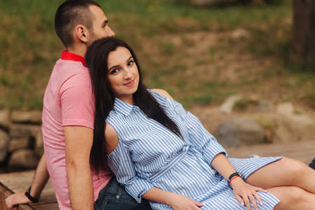 A guy and a girl enjoy each other in a romantic atmosphere, sits on the pierの写真素材