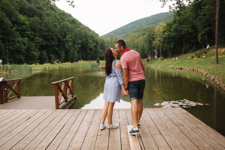 Beautiful couple walking in the park near the lakeの写真素材