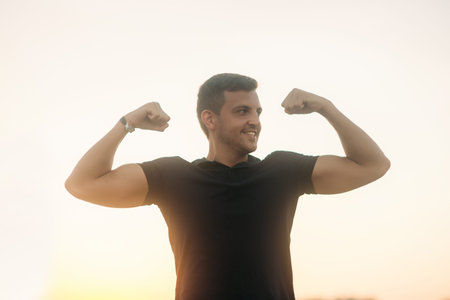 Handsome man standing on pier near the sea in sunset time