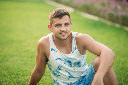 Smiled man in shorts and shirt in summer time walks near the parkの写真素材