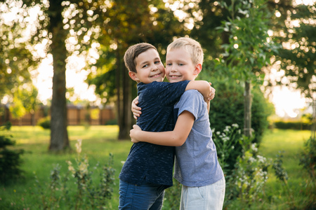 Two children boys friends walking in the park on a sunny summer dayの写真素材
