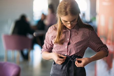 Mid section of waitress wearing apron at cafeの写真素材
