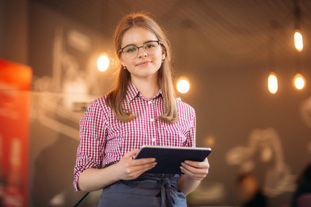 Attractive young waitress using a tablet computerの写真素材