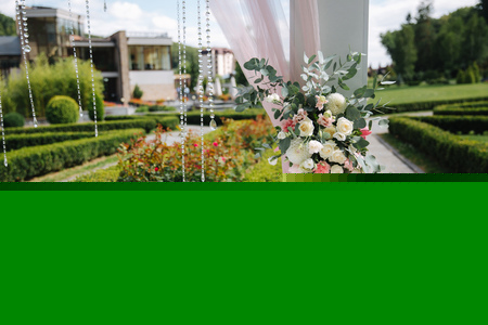 Weddind decoration on open air. Floral decor of a beautiful white arch. Beautiful beckground view of treesの写真素材