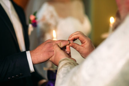 The bride and groom give a vow of love in the church. wearing a ringの写真素材