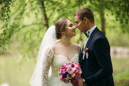 The newlyweds are walking in the park on the wedding day. The bride and groom Enjoying at the wedding dayの写真素材