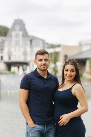 Pregnant woman and her husbant hug each other and smileの写真素材